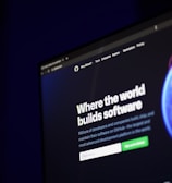 A computer screen displays a website with the text 'Where the world builds software' prominently featured. Below the text, there are fields for users to input their email address, along with additional descriptions about the platform and its capabilities. The website has a dark background with bright text, indicating a professional tech-based service.